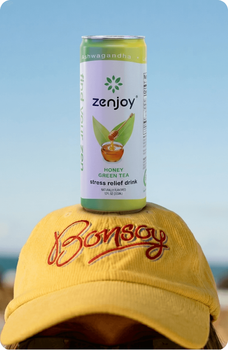 A Honey Green Tea can balanced on a yellow cap